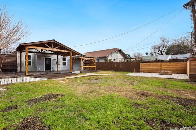 exterior space with a deck, a patio area, and a lawn