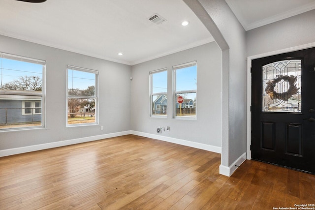 entryway with hardwood / wood-style flooring and crown molding