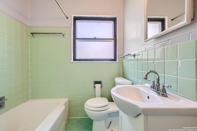 full bathroom with tile walls, tile patterned flooring, vanity, tiled shower / bath combo, and toilet