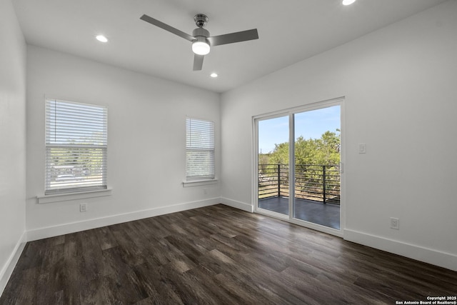 empty room with a healthy amount of sunlight, dark wood-type flooring, and ceiling fan