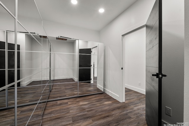 walk in closet with dark wood-type flooring