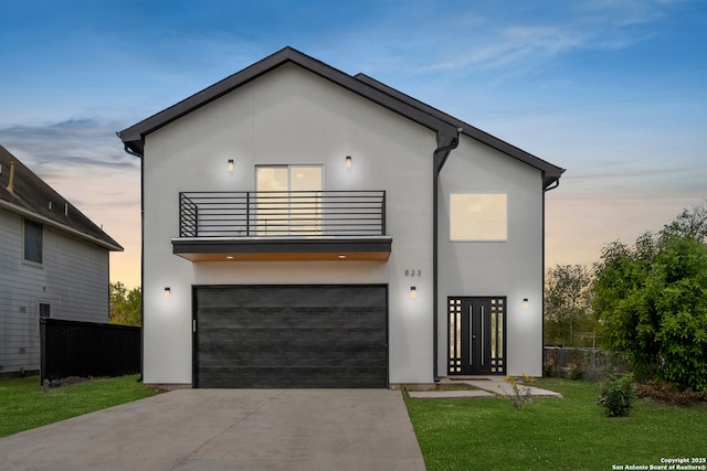 contemporary house with a balcony, a garage, and a yard