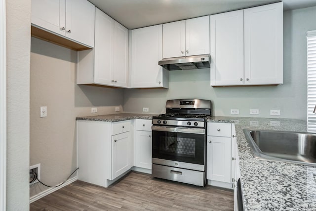 kitchen featuring light hardwood / wood-style flooring, sink, stainless steel gas range oven, and white cabinets