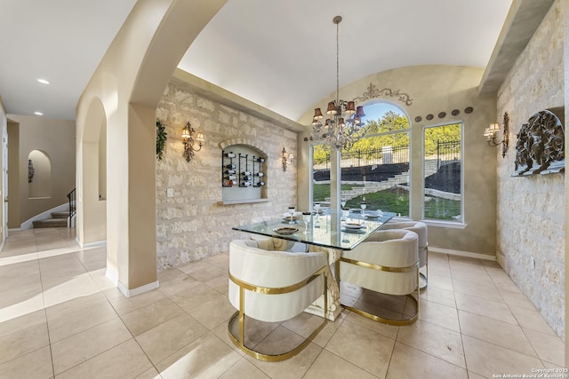 tiled dining space featuring lofted ceiling and an inviting chandelier