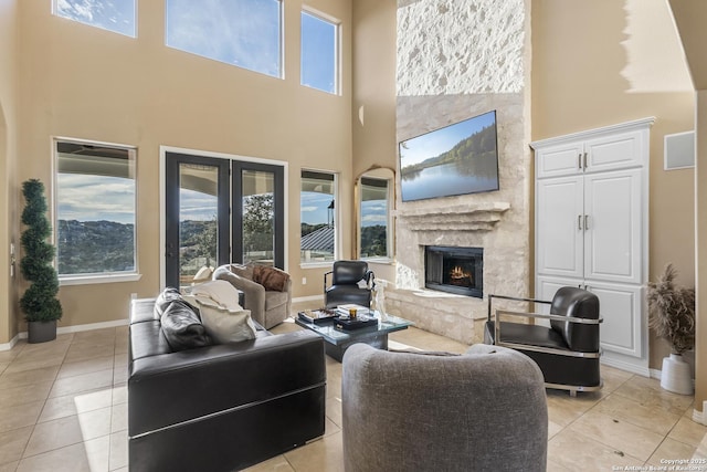 tiled living room with a fireplace, french doors, and a high ceiling