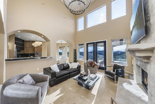 living room featuring light tile patterned floors, a high ceiling, and a notable chandelier