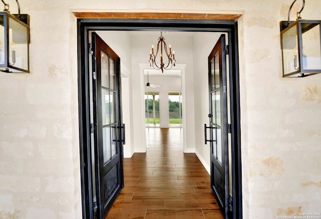 hall featuring french doors and a chandelier