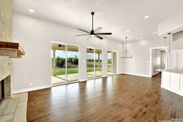 unfurnished living room featuring ceiling fan and a fireplace