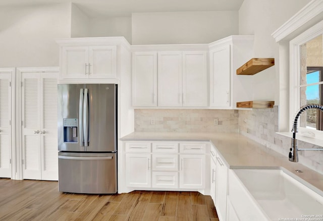 kitchen with white cabinetry, sink, and stainless steel refrigerator with ice dispenser