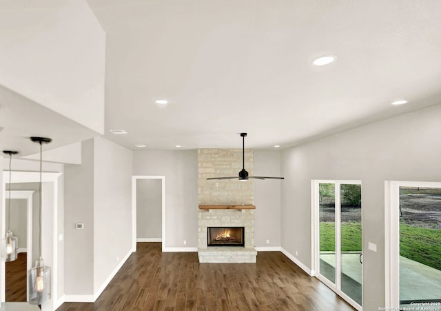 unfurnished living room with ceiling fan, dark hardwood / wood-style floors, and a fireplace