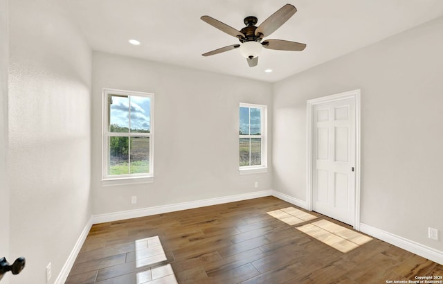 empty room with dark wood-type flooring and ceiling fan