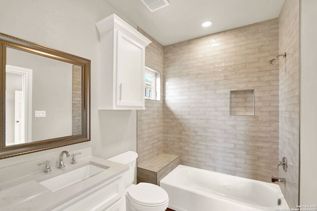 full bathroom featuring tiled shower / bath, vanity, and toilet