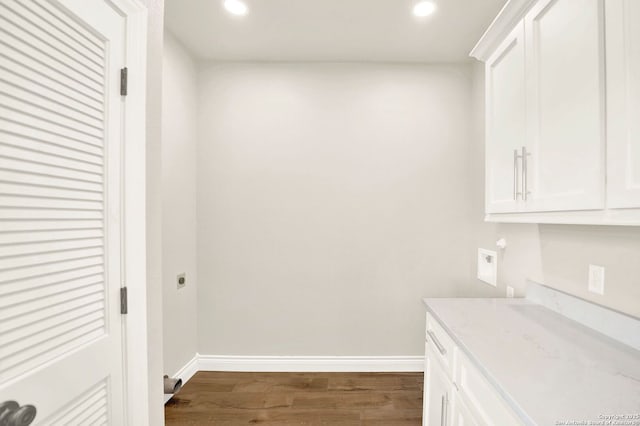 washroom with cabinets, electric dryer hookup, dark wood-type flooring, and hookup for a washing machine