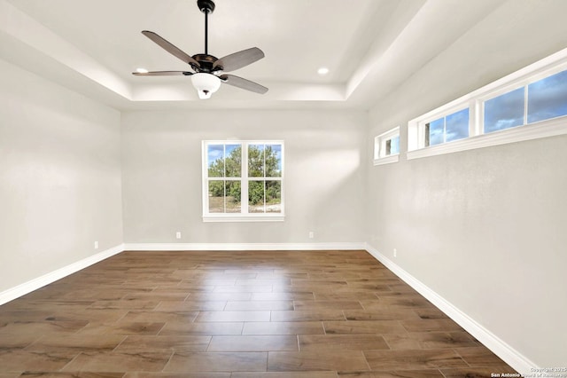 unfurnished room featuring a raised ceiling and ceiling fan