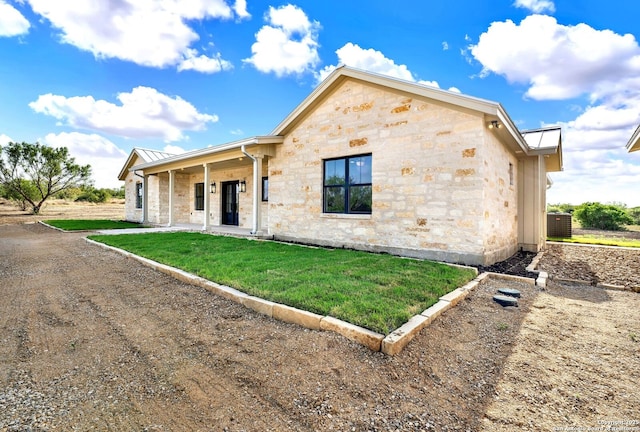 view of front of house featuring a porch, central AC unit, and a front lawn