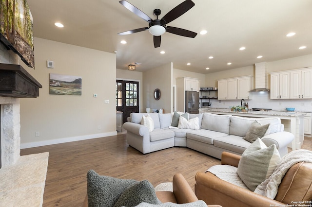 living room featuring ceiling fan and light hardwood / wood-style flooring