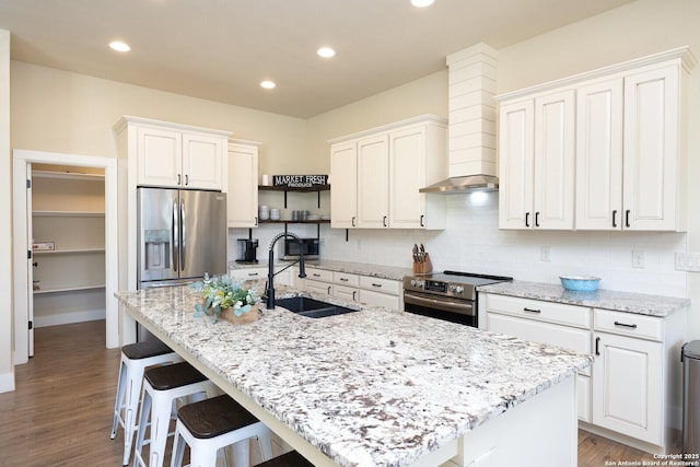 kitchen with sink, stainless steel appliances, and an island with sink