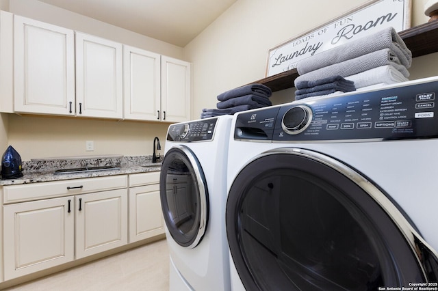 clothes washing area with cabinets, sink, and washing machine and dryer