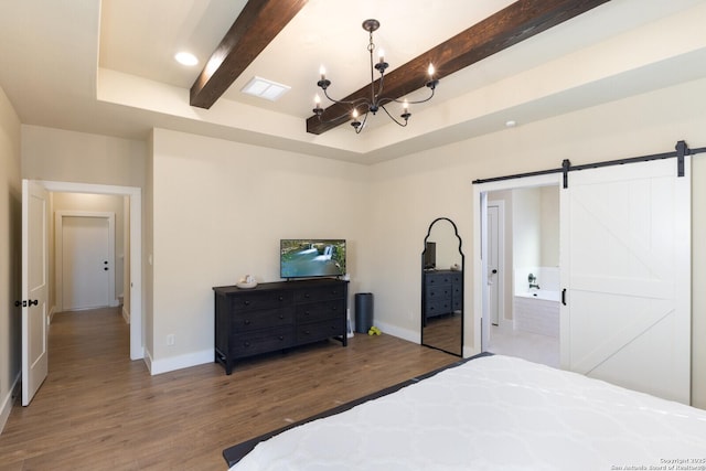 bedroom with beamed ceiling, a barn door, a chandelier, and hardwood / wood-style floors