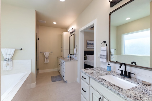 bathroom featuring tile patterned floors, vanity, and tiled tub