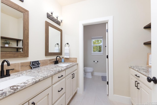 bathroom with vanity, tile patterned flooring, and toilet