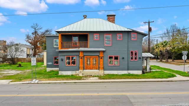 view of front of house featuring a balcony and a front yard