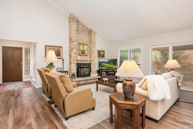 living room featuring a brick fireplace, hardwood / wood-style flooring, ornamental molding, and high vaulted ceiling