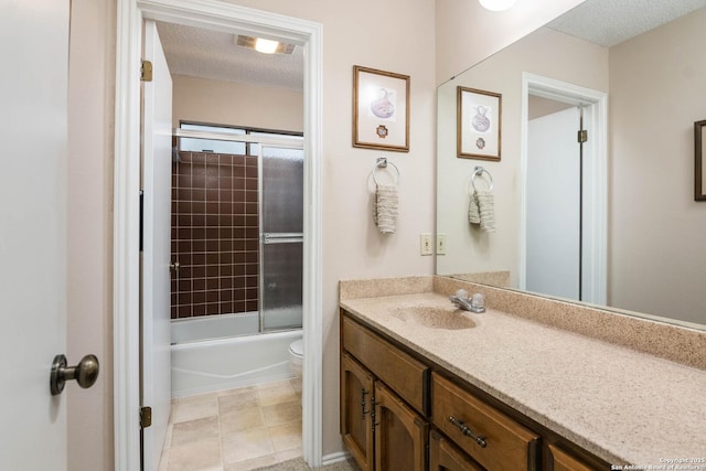 full bathroom featuring bath / shower combo with glass door, vanity, a textured ceiling, and toilet