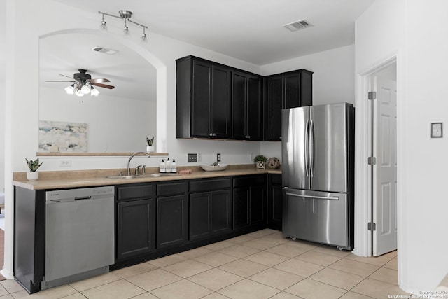 kitchen featuring stainless steel appliances, sink, light tile patterned floors, and ceiling fan