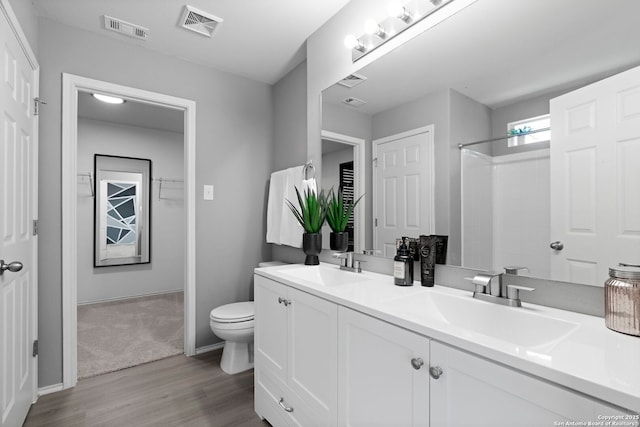 bathroom featuring vanity, hardwood / wood-style floors, and toilet