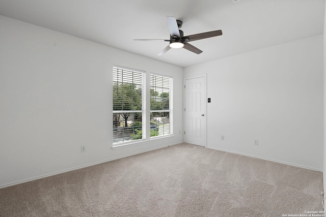 carpeted spare room with ceiling fan