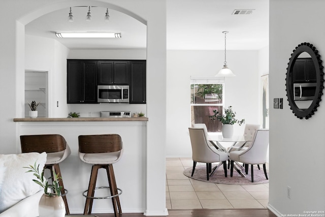 kitchen with light tile patterned floors and decorative light fixtures