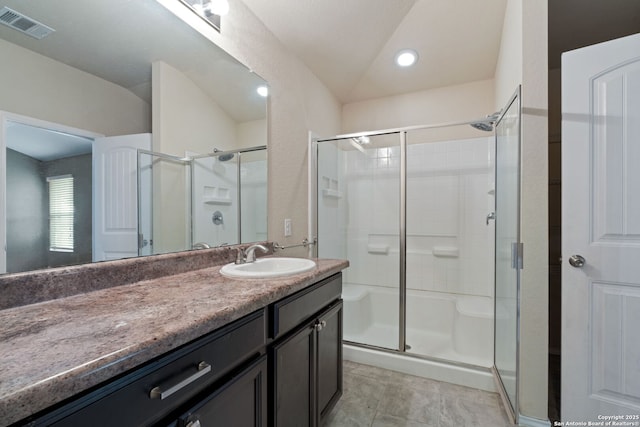 bathroom with tile patterned flooring, vanity, vaulted ceiling, and walk in shower