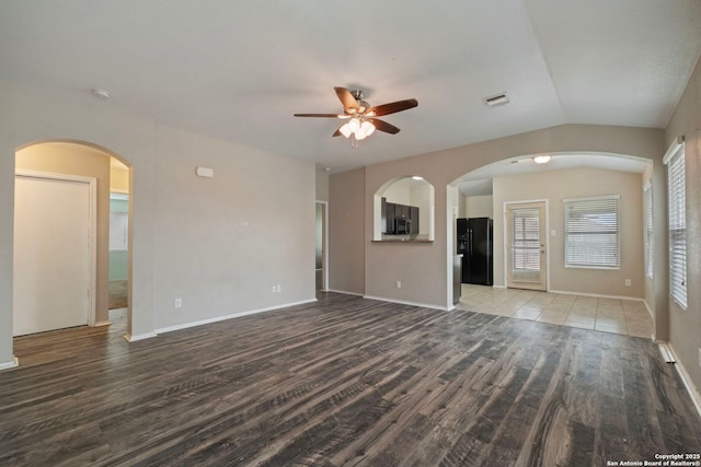 unfurnished living room featuring lofted ceiling, hardwood / wood-style floors, and ceiling fan