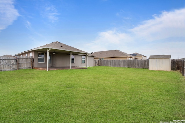 back of property featuring a patio area, a lawn, ceiling fan, and a storage unit