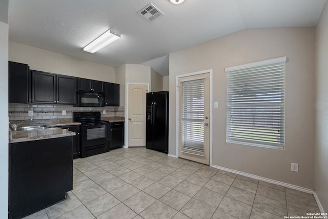 kitchen with backsplash, lofted ceiling, light tile patterned floors, and black appliances