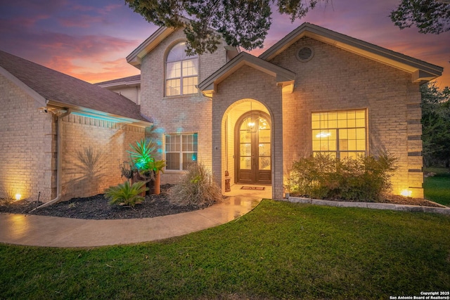 view of front of property featuring a yard and french doors