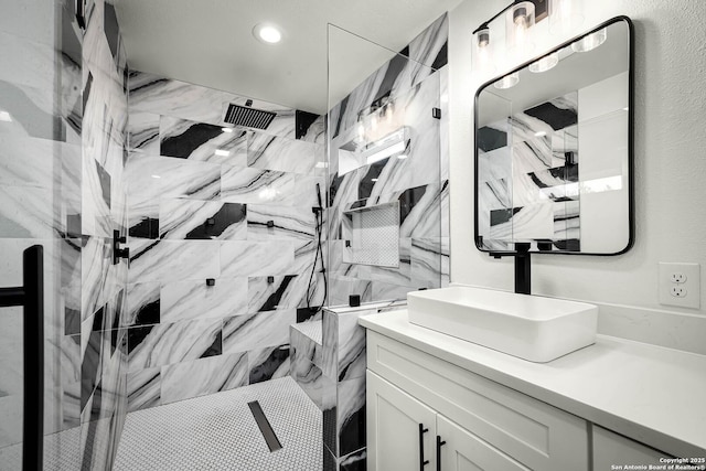 bathroom with vanity and a tile shower