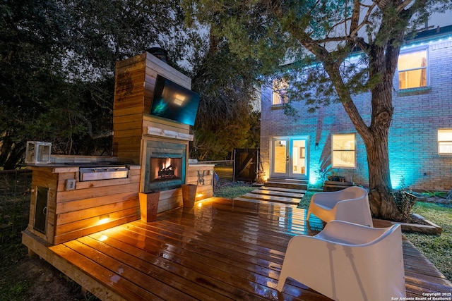 wooden deck featuring exterior fireplace