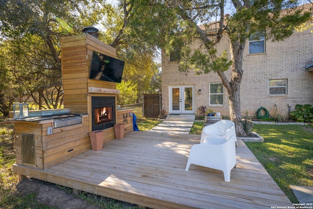 wooden terrace featuring exterior fireplace and french doors