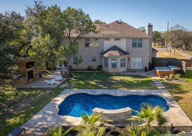 view of pool featuring exterior fireplace, a jacuzzi, a patio area, and a yard