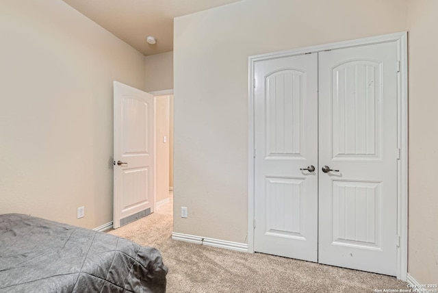 bedroom featuring light colored carpet and a closet