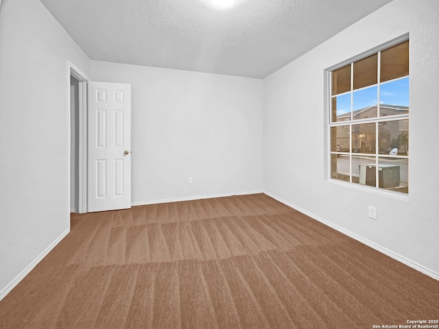 carpeted empty room with a textured ceiling