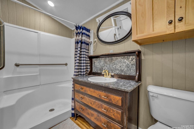 bathroom with vaulted ceiling, curtained shower, ornamental molding, vanity, and toilet