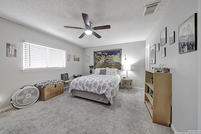 carpeted bedroom with a textured ceiling and ceiling fan