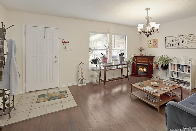 entryway with wood-type flooring, a notable chandelier, and a textured ceiling