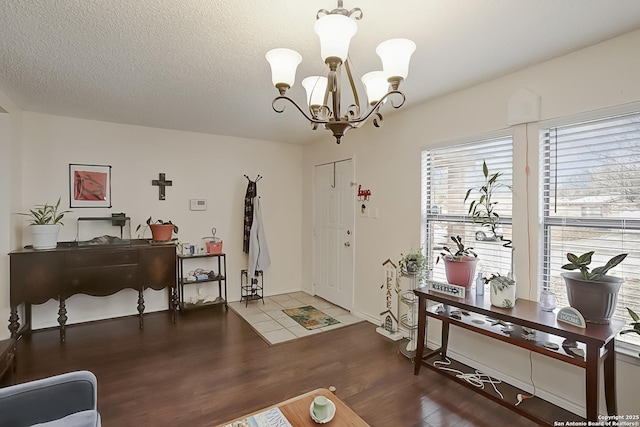 entrance foyer featuring dark hardwood / wood-style floors, a chandelier, and a textured ceiling