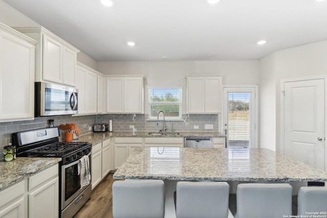 kitchen featuring white cabinetry, stainless steel appliances, sink, and a kitchen island