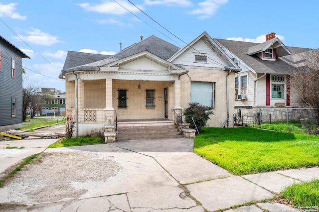 bungalow-style home with a front lawn and a porch