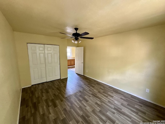 unfurnished bedroom featuring dark hardwood / wood-style floors, ceiling fan, and a closet